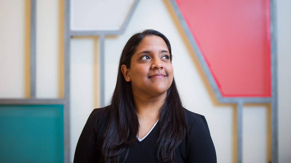 Head and shoulders of Swarna Jeewajee and she's looking up to the left and smiling.