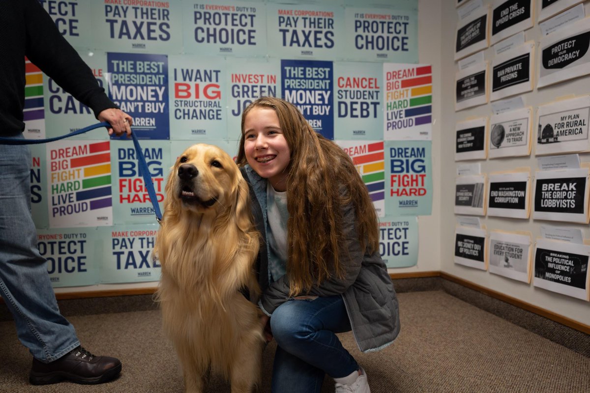 A supporter poses for a selfie with Elizabeth's dog, Bailey.