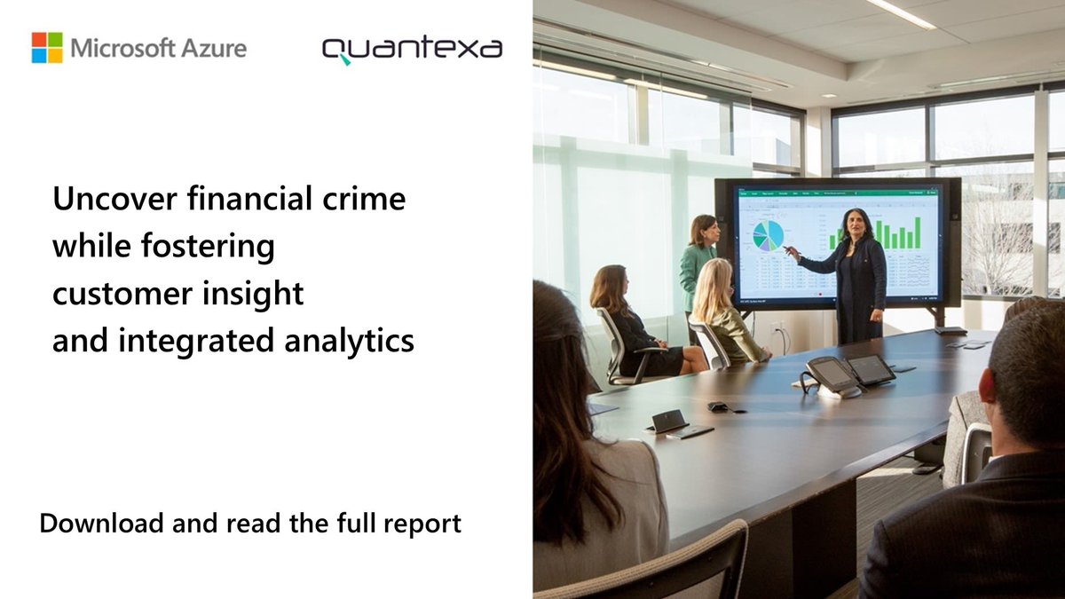 Photo of people around  a large conference table while watching a presentation. 