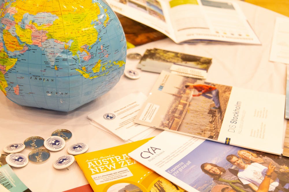Blow up globe on table next to piles of study abroad flyers and brochures