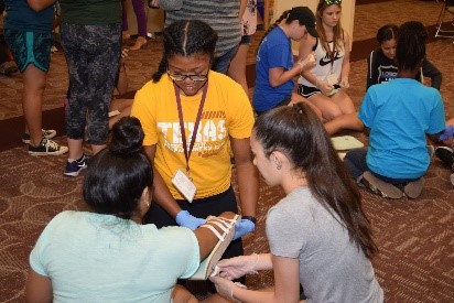 three teens learning how to splint an arm