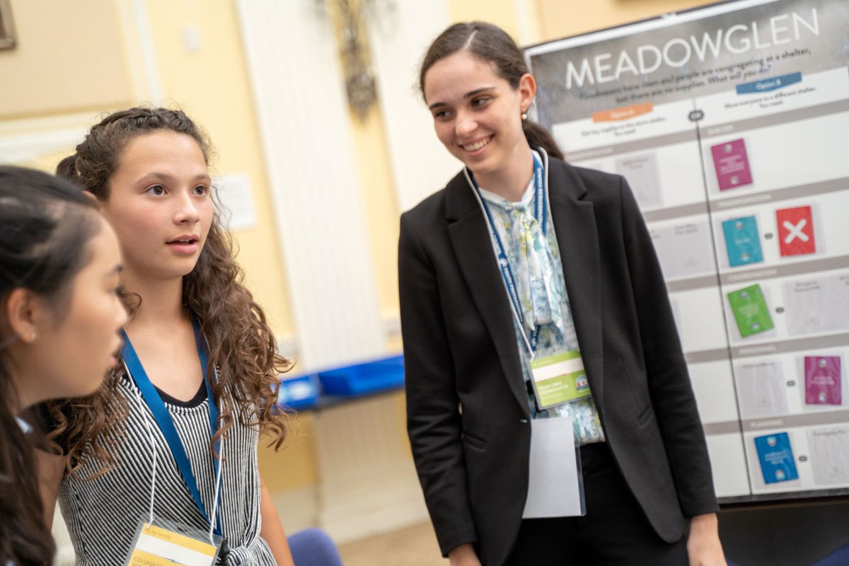 three teens inside talking in front of poster