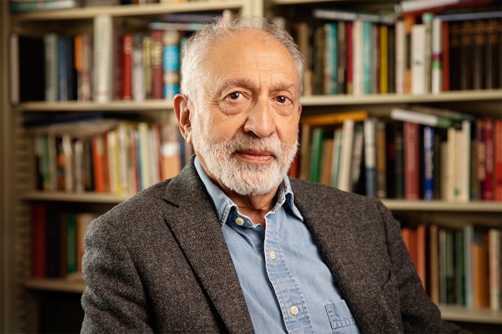 Dennis Barron poses in front of a full bookcase.