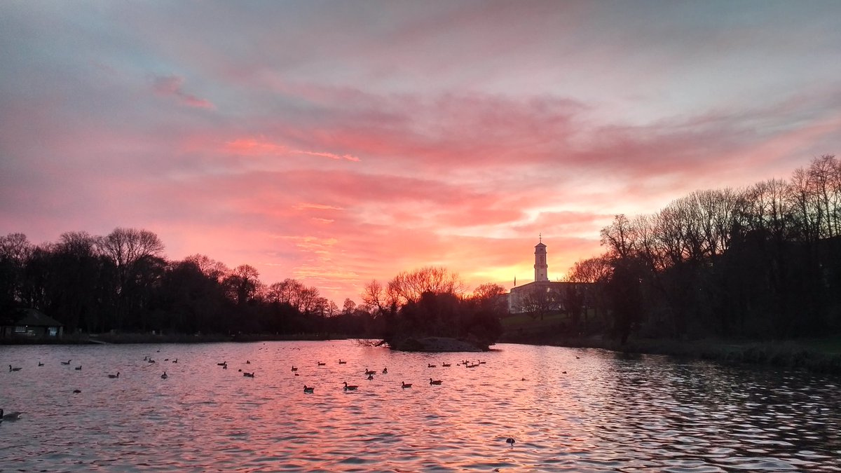 Sunset viewed the side of the lake at University Campus with Trent Building's dark outline