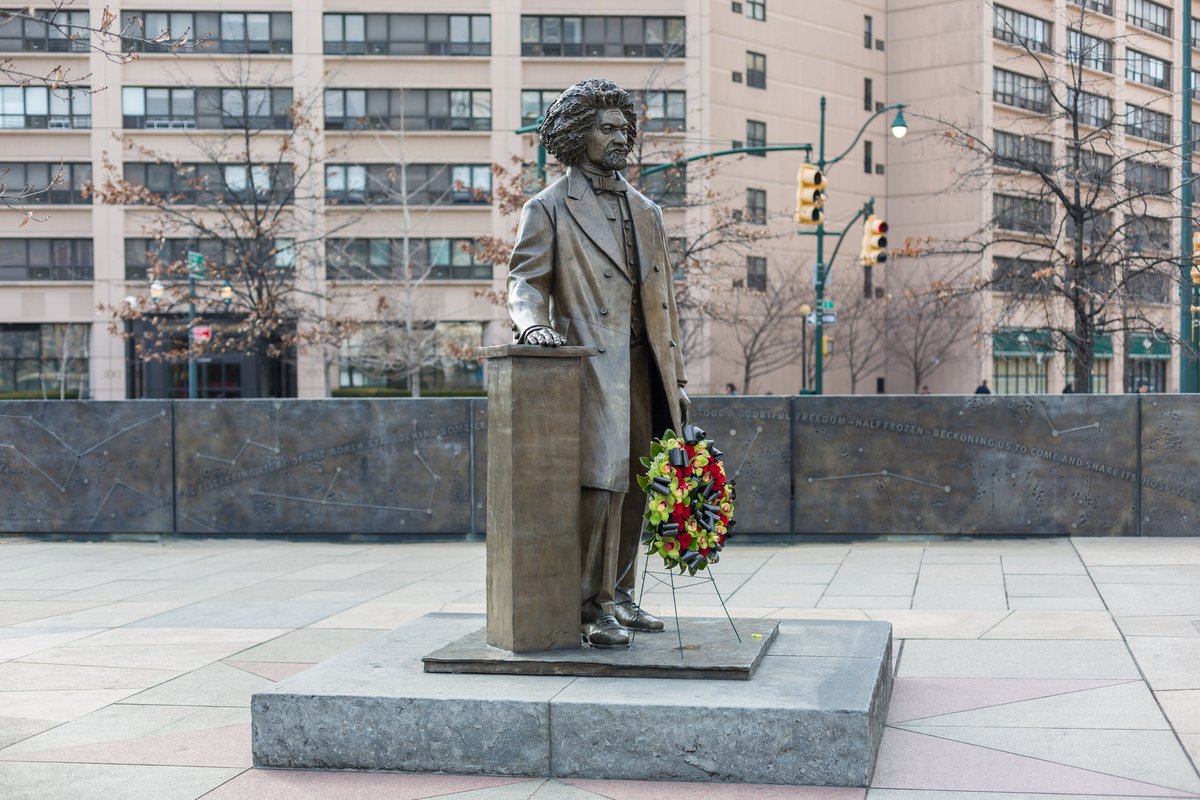 A sculpture honoring Frederick Douglass stands at Frederick Douglass Circle. A wreath stands next to the sculpture honoring 200 years (in 2018) since the birth of the abolitionist, publisher, writer, and orator. 