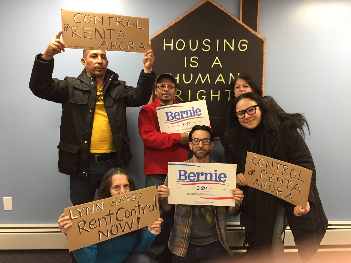 Group of 6 people posed with signs including Bernie 2020, Lynn Says Rent Control Now, and Housing is a Human Rights.