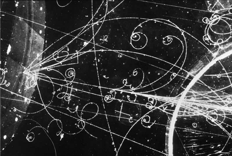 Bubble chamber image--a black background covered in white spirals.