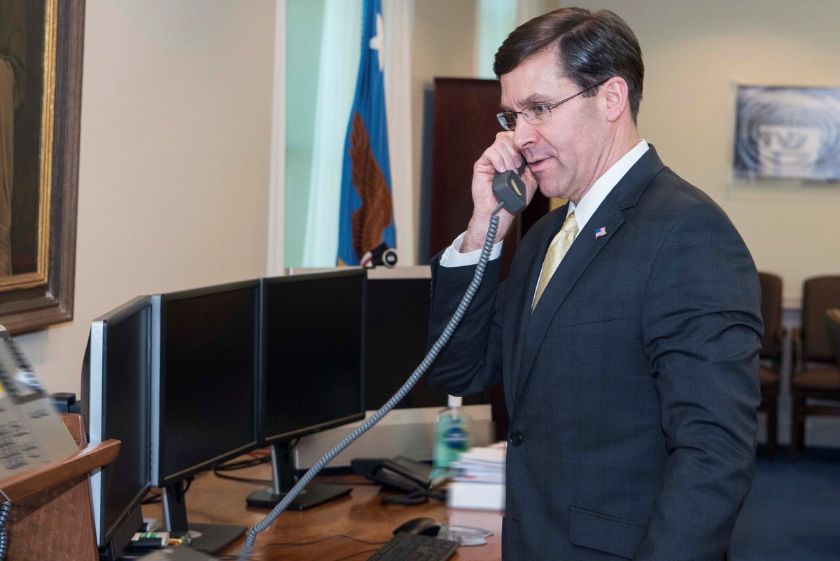 Esper, standing, is talking on phone from his office at the Pentagon.