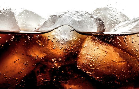Close-up photo of soda over ice cubes.