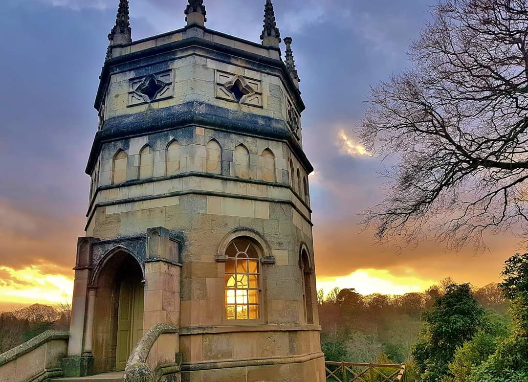 Tower with a sunset behind, glowing through a window.