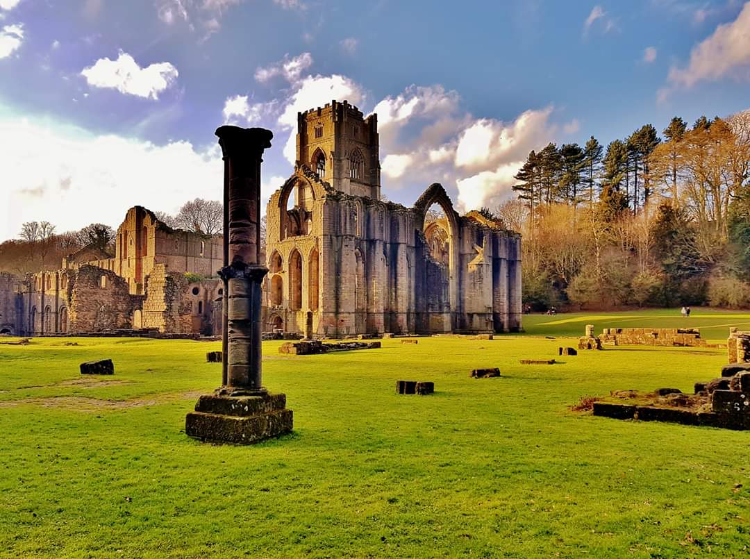 Ruins of Fountains Abbey illuminated with the low winter sun.