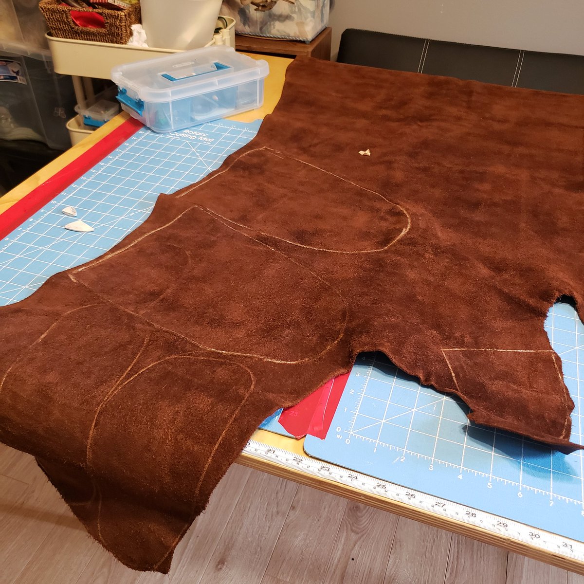 Dark brown buffalo house, suede side up I'm a cutting table with pattern pieces traced onto it