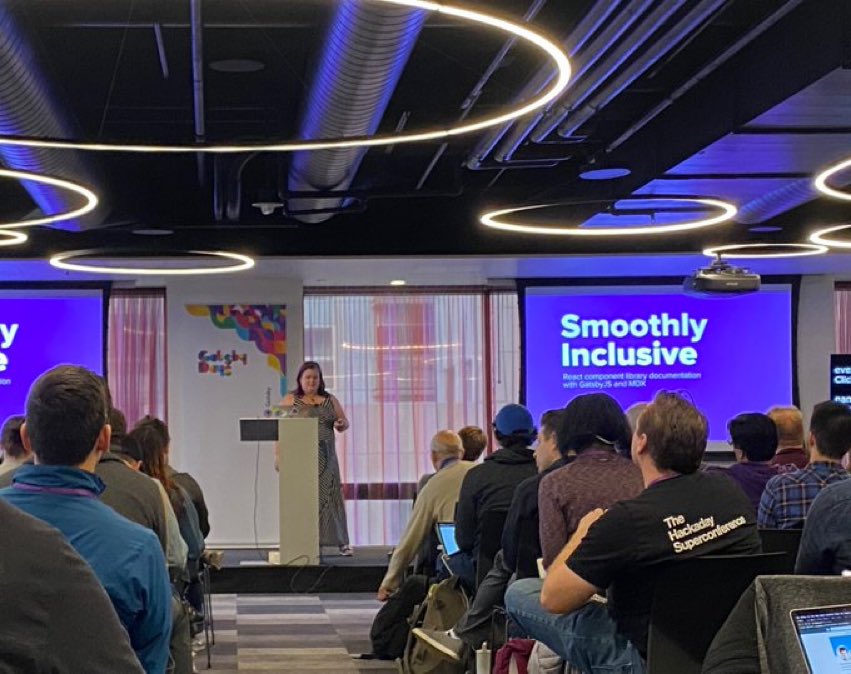 Kathleen McMahon in front of a podium giving a talk at Gatsby Days LA