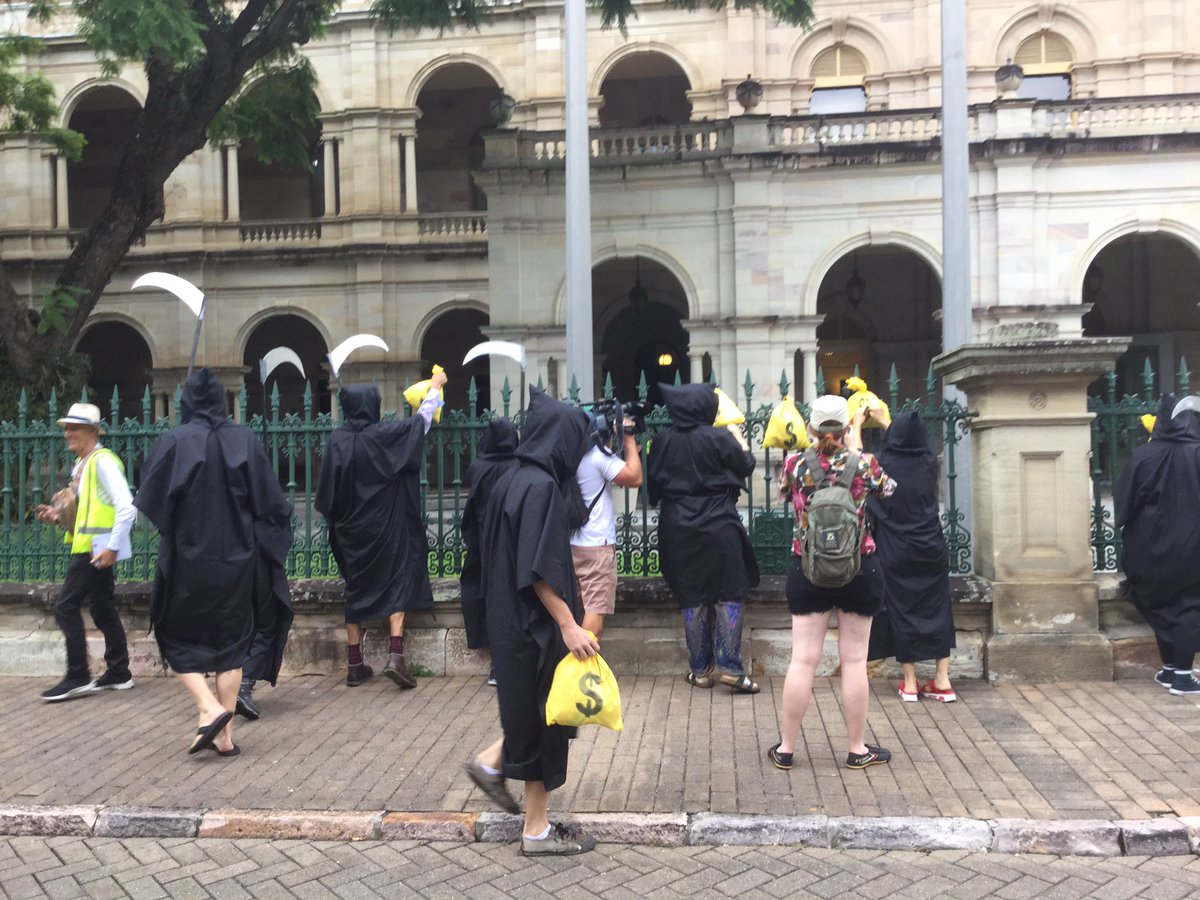 Grim reapers hanging bags of dirty coal money on Parliament House fence.
