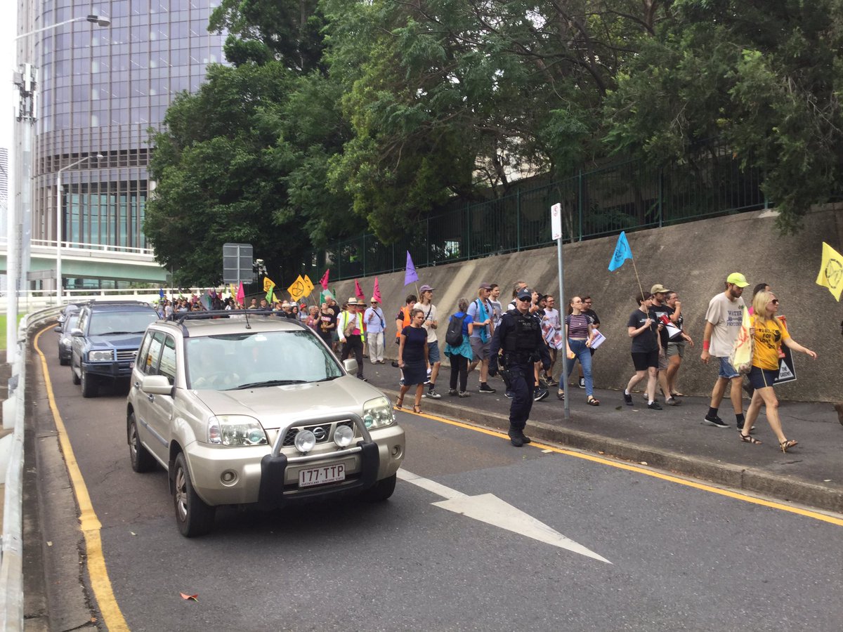 A crowd of protestors marching towards the back gate of Parliament House.