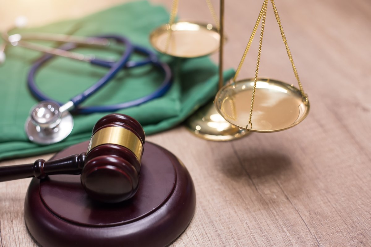 Gavel and scale with medical scrubs