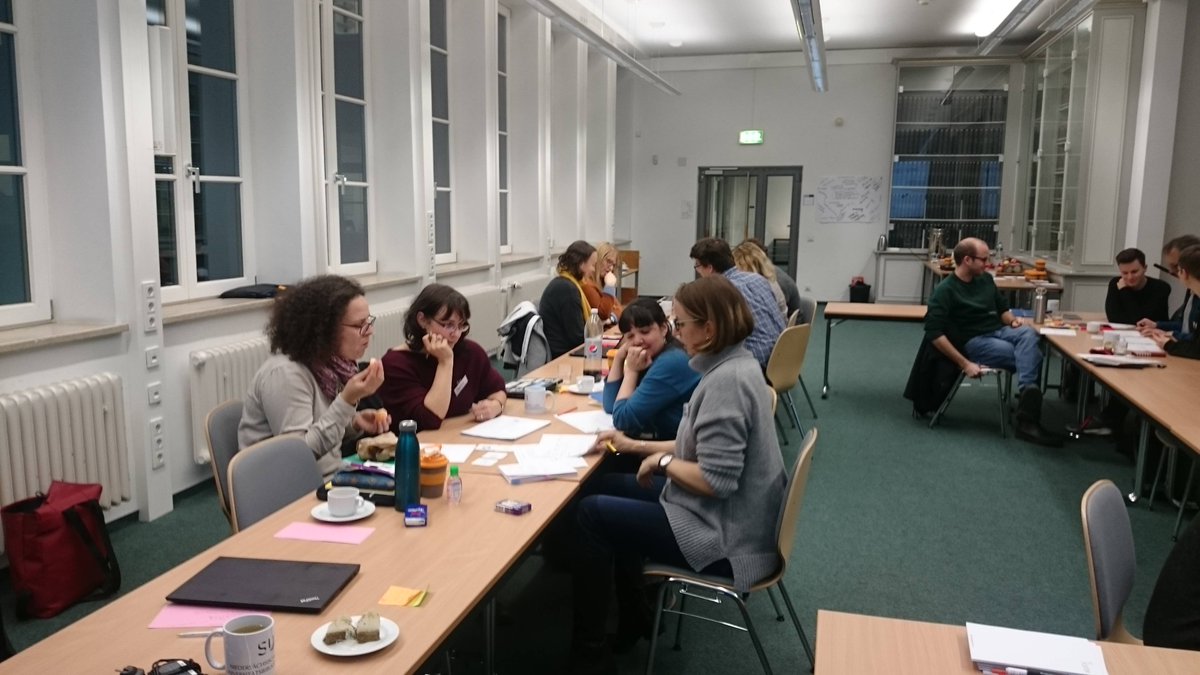 Our group discussing the outline of the training - A group of four people sits in a seminar room next to two other groups discussing. @opensciradio