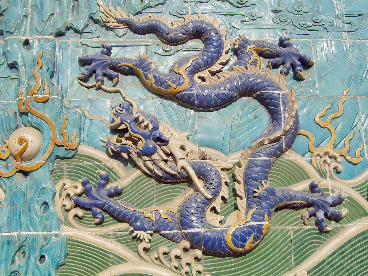 Ancient Chinese tile work depicts an indigo blue dragon against a light blue and green background.