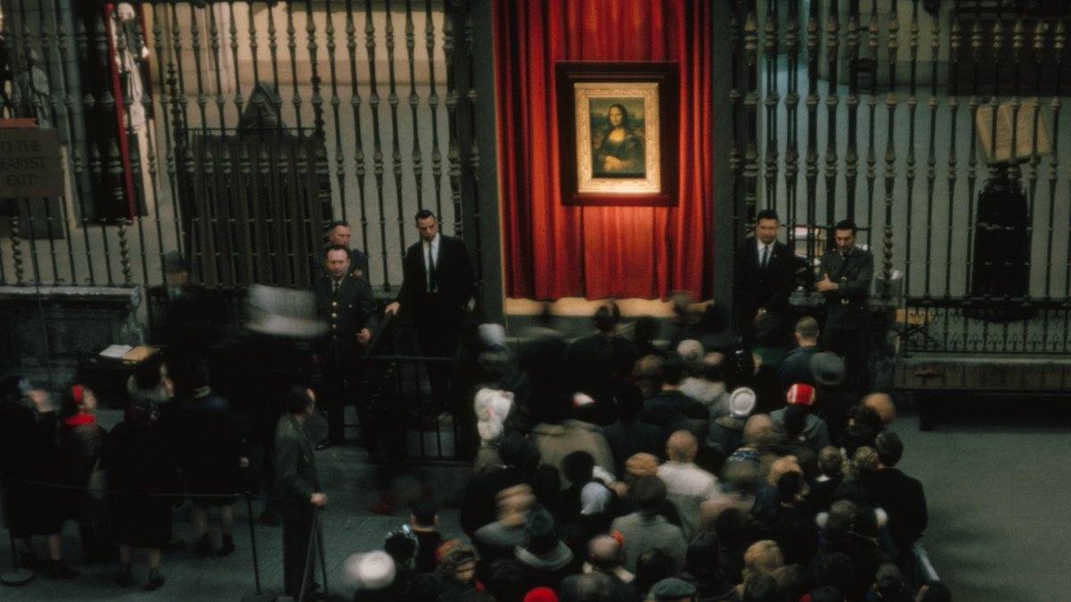 A crowd waits in line in the Medieval Sculpture Hall to see the Mona Lisa.