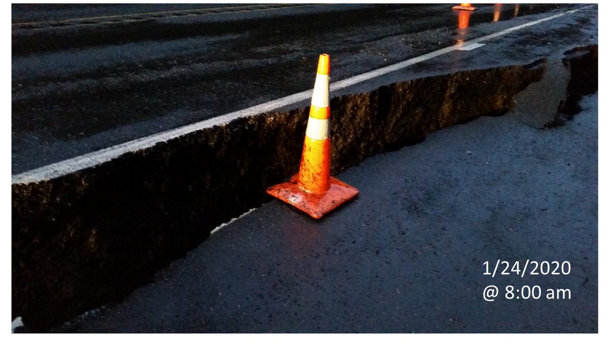 Traffic cone next to a crack in pavement. The crack is 2/3 as deep as the cone is tall (1/24/2020)