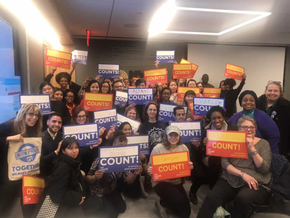 A photo of many people holding up signs for the census.