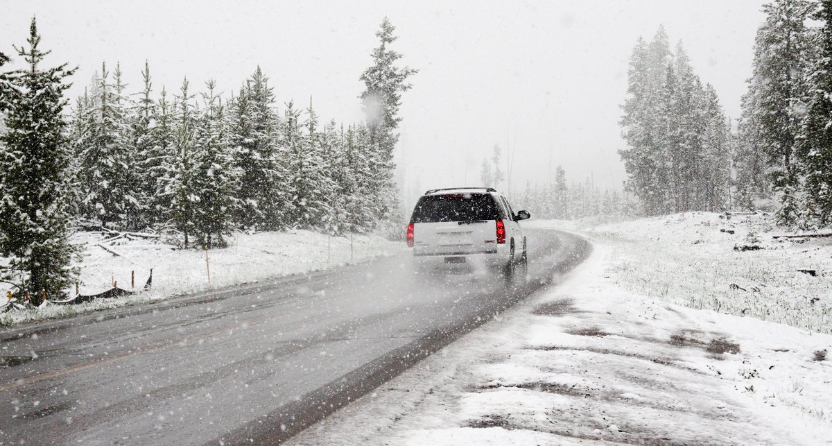 SUV on winding road in the snow.