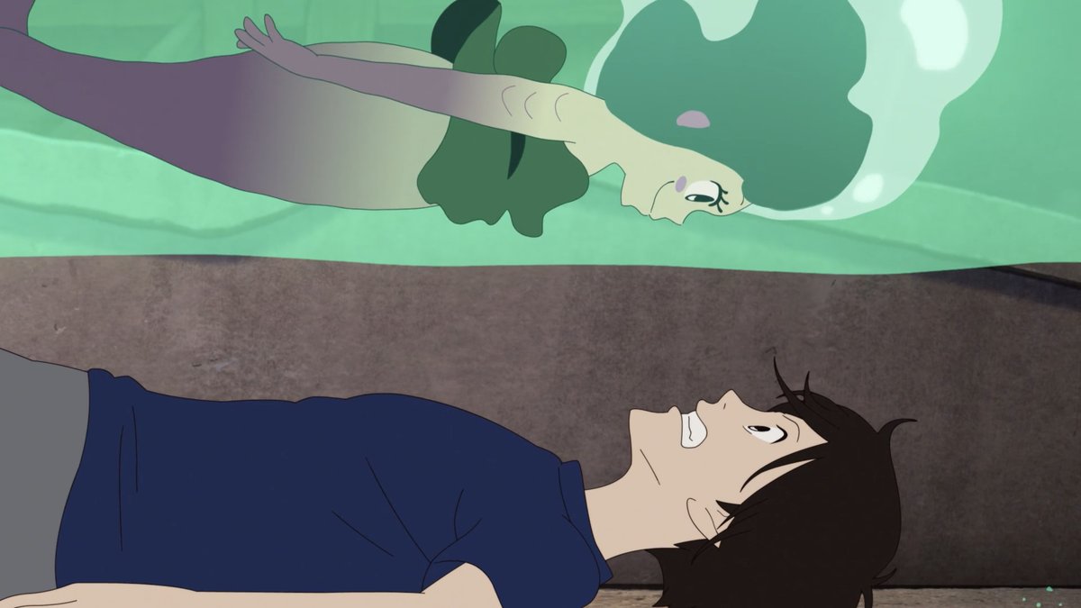 A brown-haired boy in a dark blue shirt is looking up in shock. Directly above him, encased in green water that is seemingly solid, is a mermaid with green hair and a seaweed top who is smiling down at him. Movie is LU OVER THE WALL.