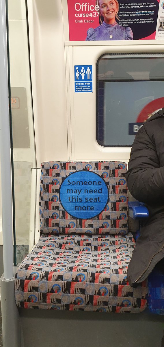 Priority seat sticker above seat with message on seat back.