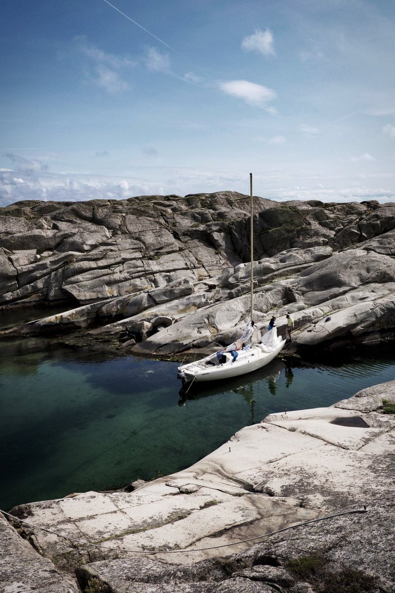 A white sailing boat among smooth cliffs