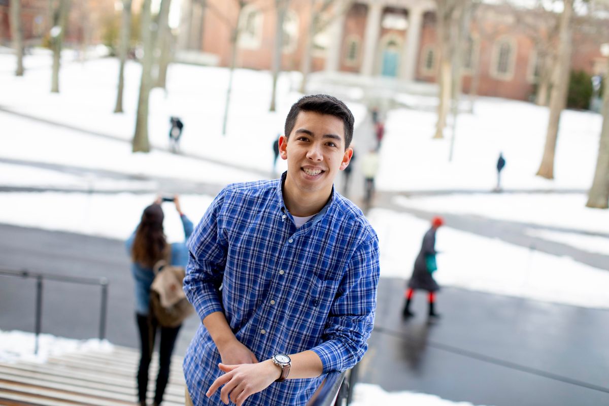 A student stands in front of the snow-covered Harvard Yard