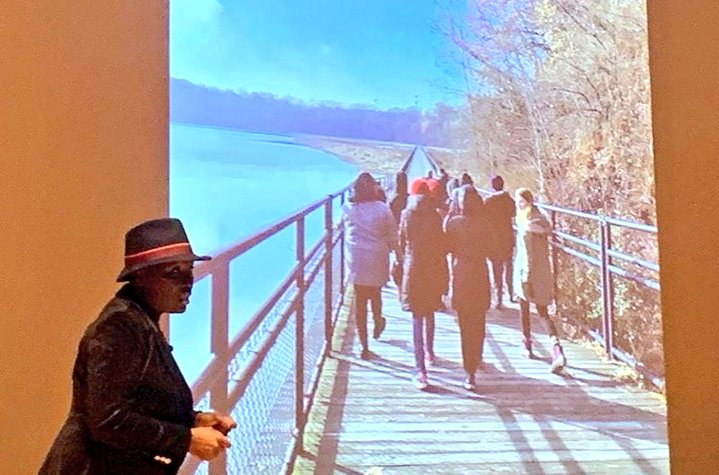 Presentation tonight at MAG. Group if people walking on a walkway.