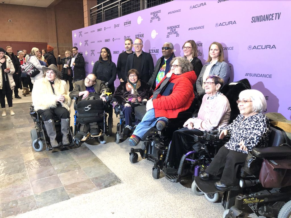 Judy with the Netflix and Crip Camp crew standing in front of a purple Sundance backdrop 