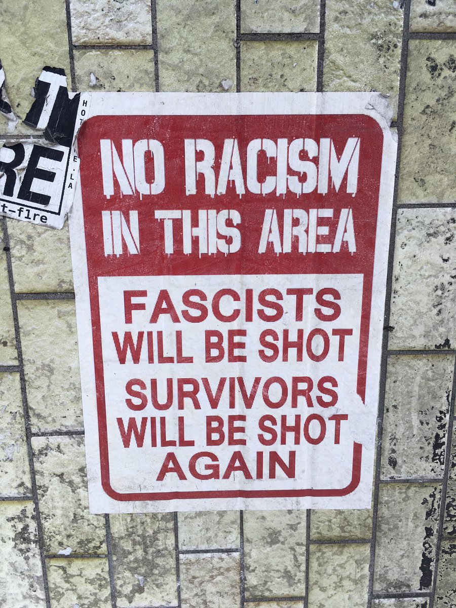 poster with the words “no racism in this area”, “fascists will be shot”, and “survivors will be shot again”