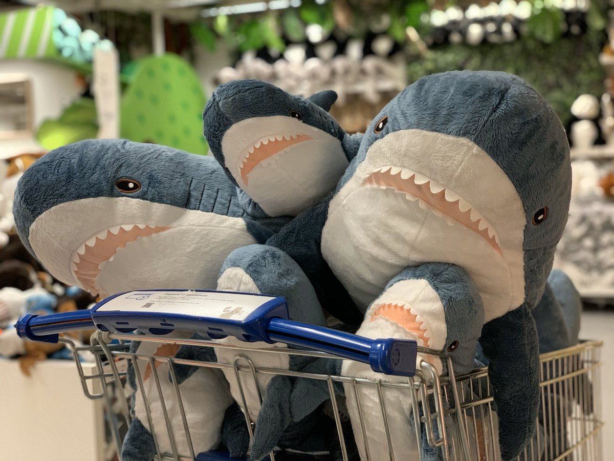 Many IKEA BLÅHAJ plus sharks in a shopping cart