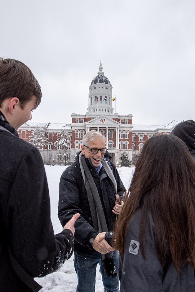 Dr. Bill Stackman smiles as he shakes an incoming Mizzou student’s hand in front of Jesse Hall in the snow.