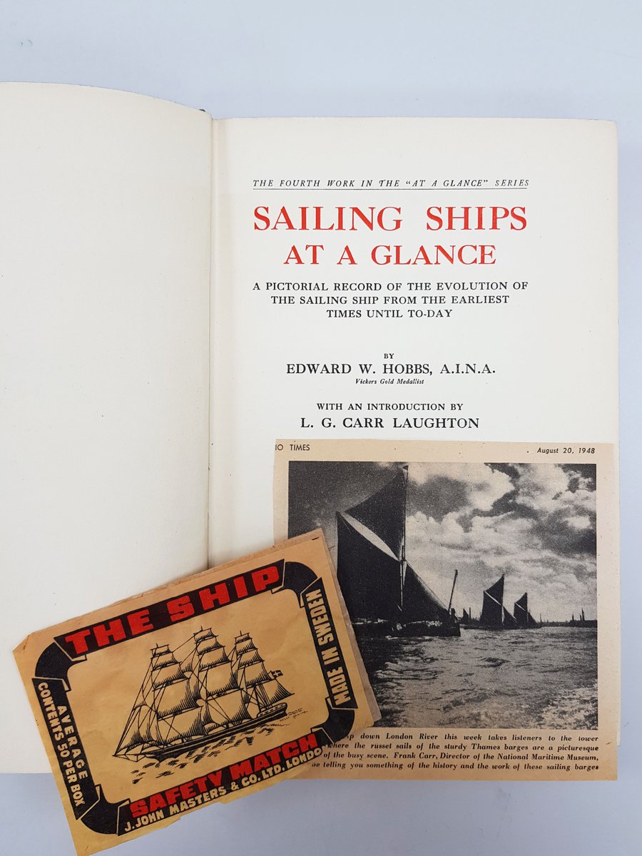 Image of book frontispiece, featuring title of the book and names of authors. Resting on top of the book is a label for The Ship Safety Match and a newspaper cutting featuring image of sailing ships