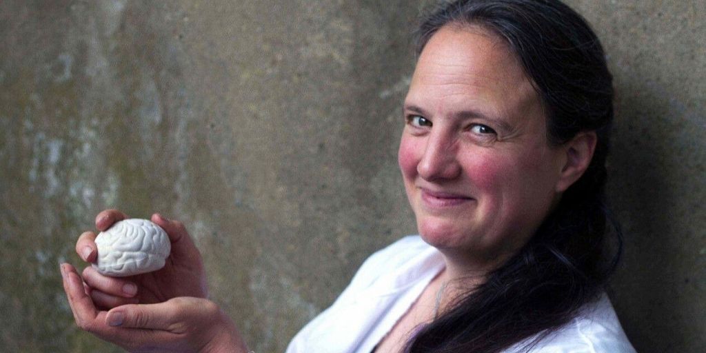 Professor Stephanie Schorge holding a small replica brain.
