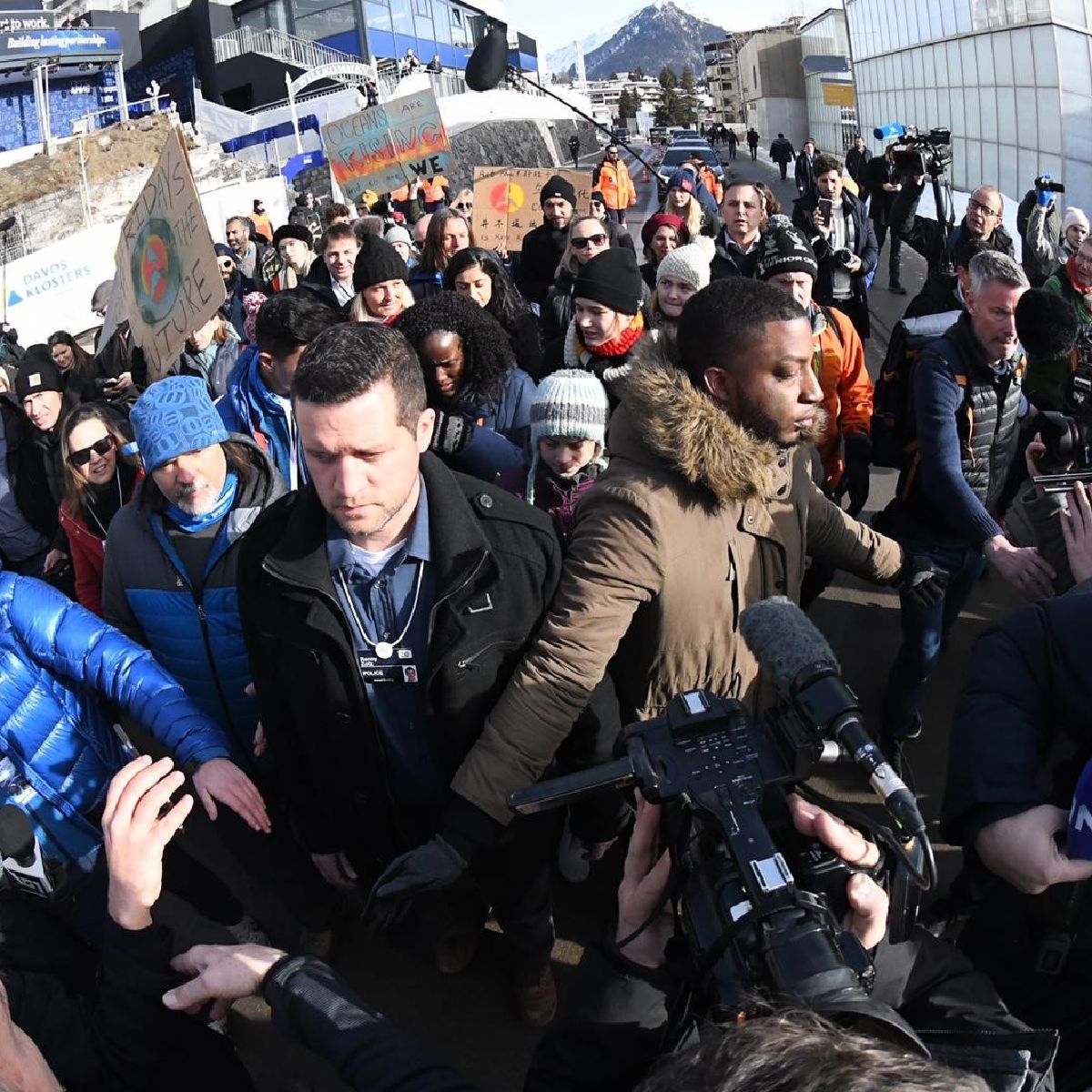 Greta Thunberg being photographed by the Press as she marches with youth climate activists in Davos.