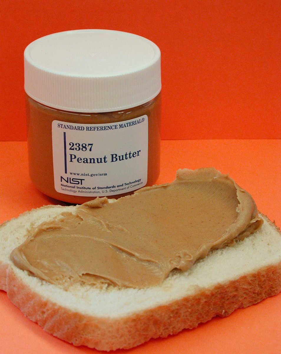 NIST peanut butter SRM alongside a slice of bread with peanut butter spread across it.