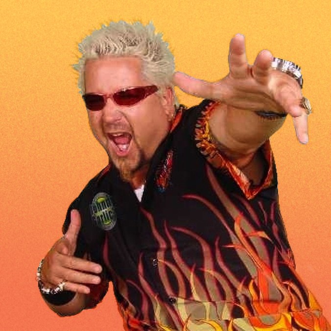 Guy Fieri posing with sunglasses and his mouth open while wearing a shirt with flames all over it