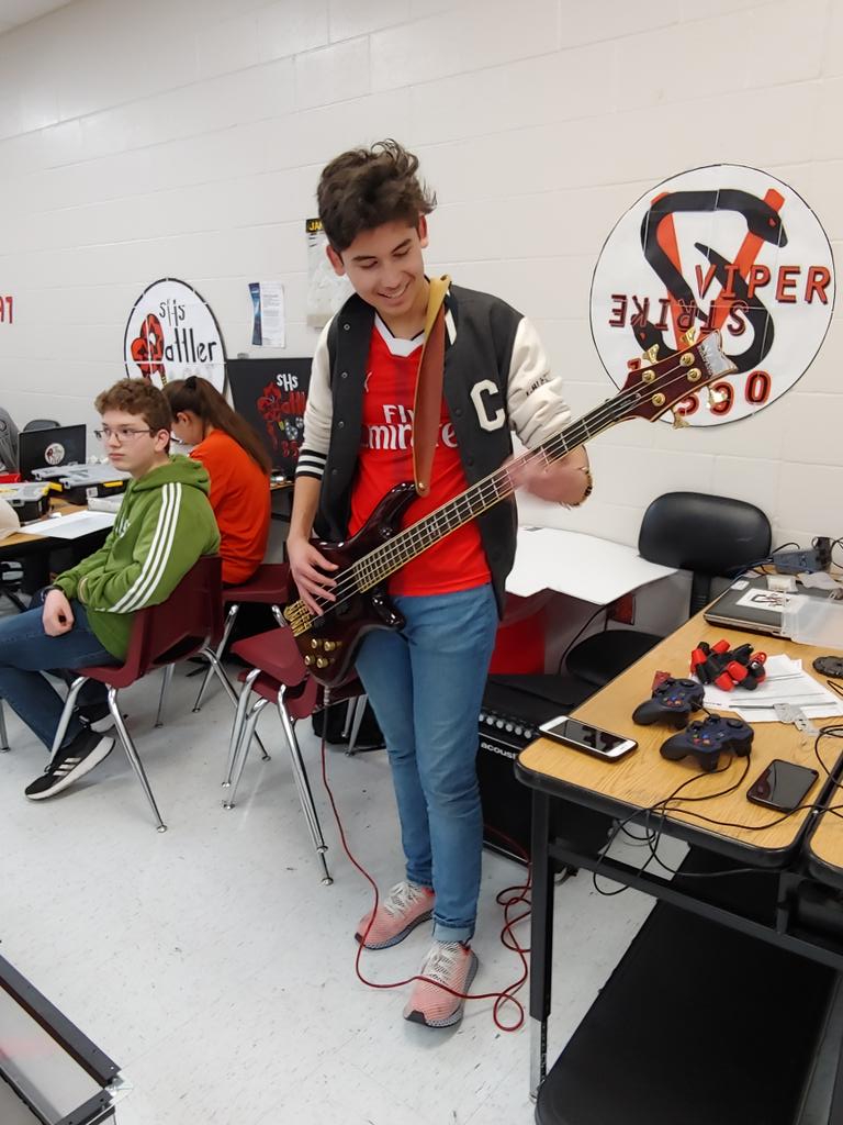 Sharylandrobots's tweet photo. While Ryan is working on the robot, Manny"Sugar" Azucar is practicing on his bass guitar for One Act Play. Yes, they do more than FIRST! @rattlerbot13588 https://t.co/bijHt5yxBd