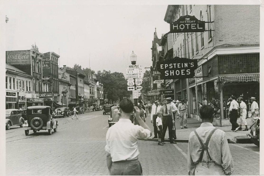OhioHistory's tweet image. This 1938 photo from our collection shows a busy downtown Lancaster at Main Street looking east.

The prominent buildings in clear view are Epstein's Shoes (founded in 1916), Mithoff Hotel (built in 1861), The Hat Box Millinery, Carr's Drugstore and the Knights of Columbus.