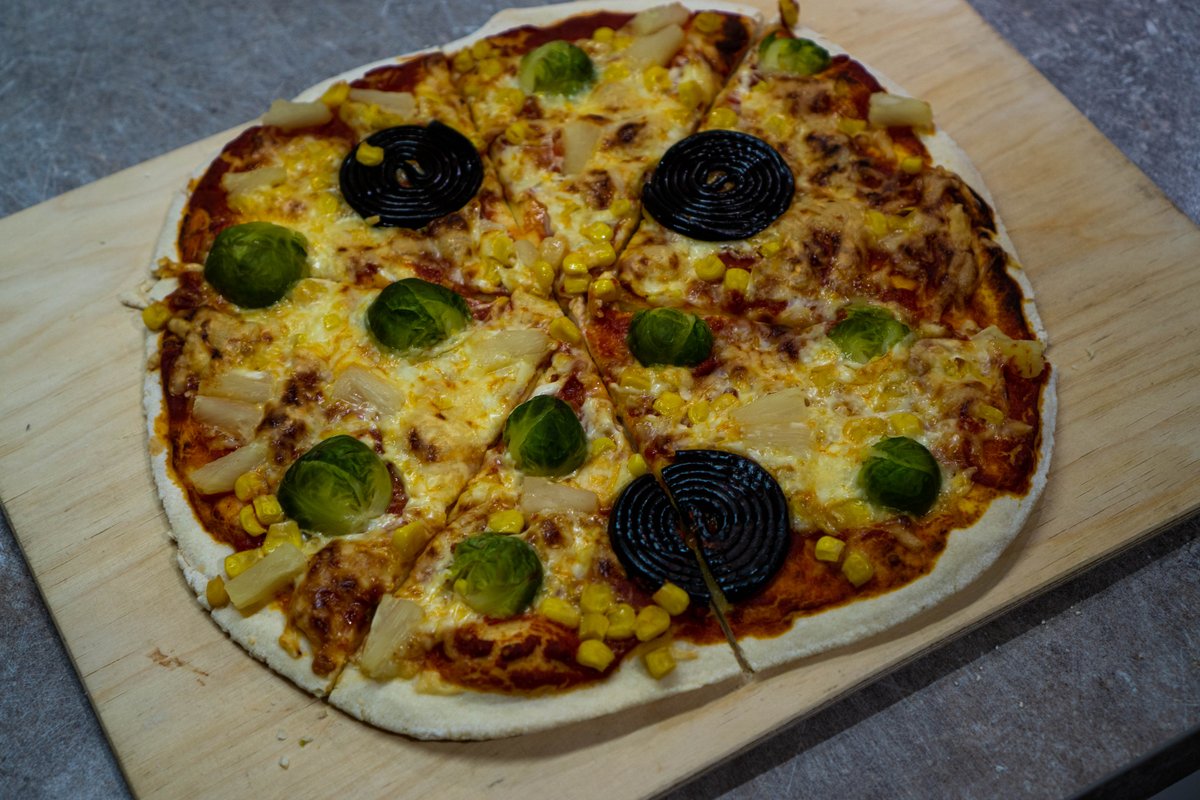 Pizza mit Mais, Ananas, Rosenkohl und Lakritzschnecken