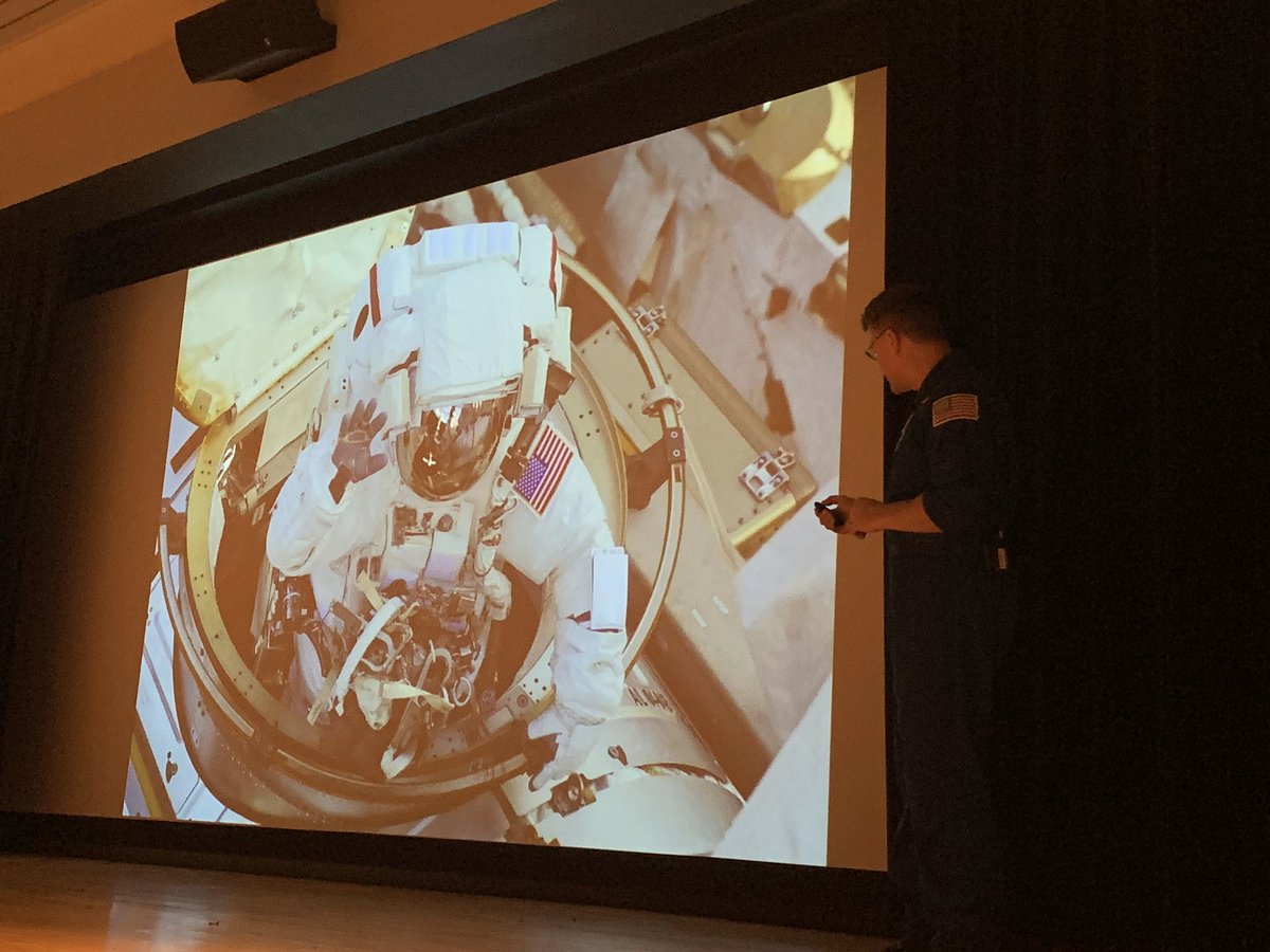 Wheels, in his suit, exits the door of the shuttle and gives a wave.
