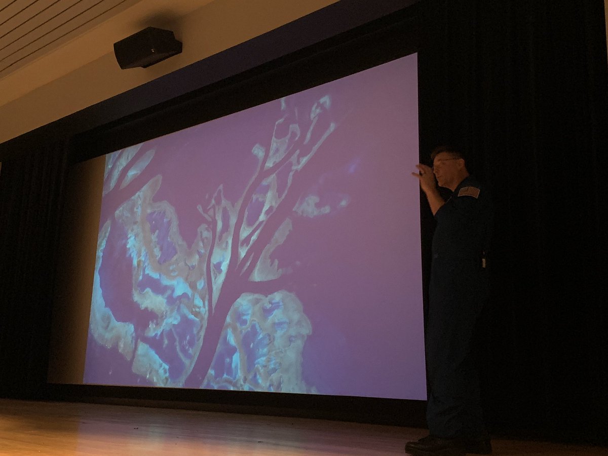 Wheels stands in front of a photo of an Earth water system.