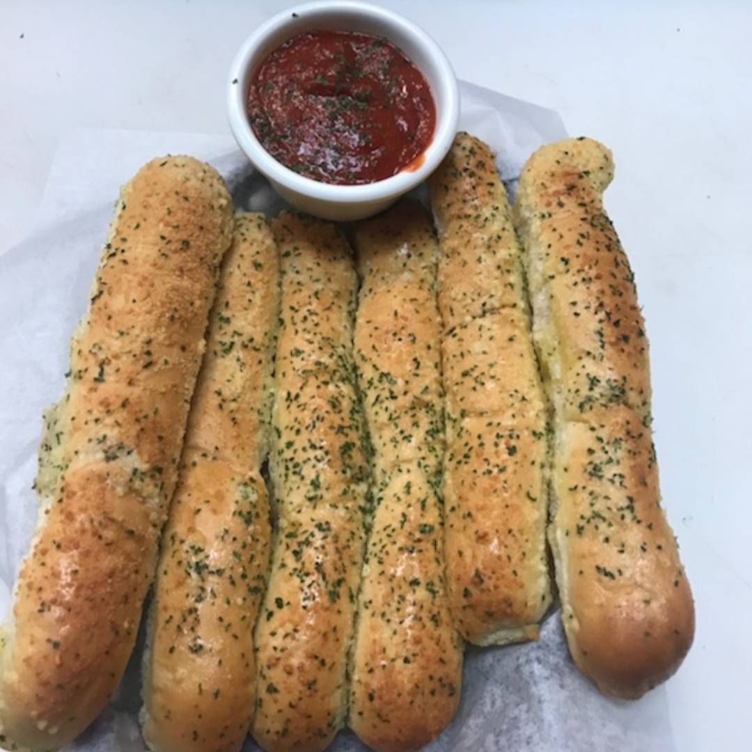 RonnallysPizza's tweet photo. Our warm garlic breadsticks are only $1 each! Paired with the red sauce it's a must have add-on 😋 https://t.co/OP3fFybjYw