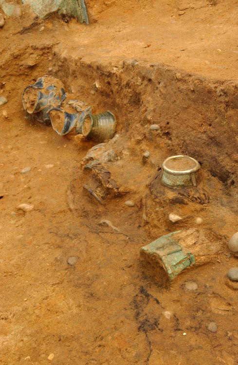Glass jars, wooden drinking vessels with decorative metal rim mounts and a drinking horn found along the east wall of the burial chamber.