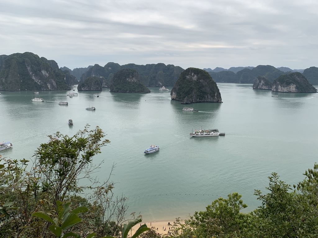 Looking into Ha Long Bay on an overcast day from Ti Top island with the beach visible at the bottom. 