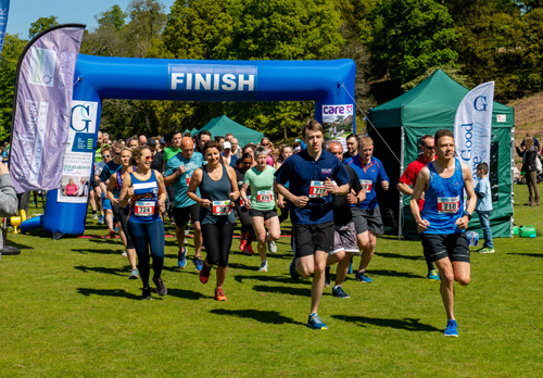 lots of people at the beginning of a race, running on grass