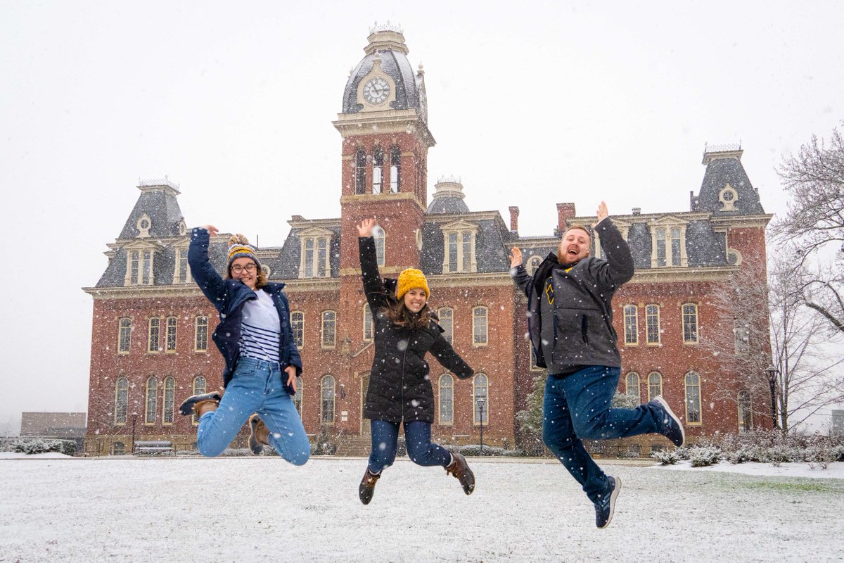 3 students jumping in the snow. 